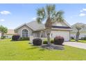 Beautiful single-story home with lush green lawn, charming landscaping, and a lovely palm tree at 10106 Duval Dr., Murrells Inlet, SC 29576