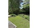 The backyard is spacious with some mature trees and lush green lawn at 105 Robin Ct., Murrells Inlet, SC 29576