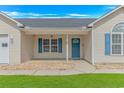Covered front porch with blue door, shutters, and pristine landscaping for a welcoming entrance at 125 Balsa Dr., Longs, SC 29568