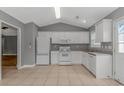 Bright kitchen with white appliances, light countertops, tile flooring, and lots of cabinet space at 125 Balsa Dr., Longs, SC 29568