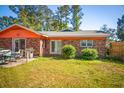 Brick house backyard featuring a lawn, patio, and sliding glass doors at 152 Gateway Dr., Little River, SC 29566