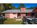 Backyard view of the house with a hot tub and patio furniture on the lawn at 152 Gateway Dr., Little River, SC 29566