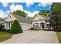 Attractive single-story home with beige siding, two car garage and beautifully manicured front lawn at 190 Barony Pl., Pawleys Island, SC 29585