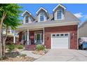 Charming brick home with dormer windows, featuring a cozy front porch and attached garage at 2019 Ye Olde Kings Hwy., North Myrtle Beach, SC 29582