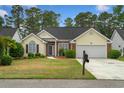 Inviting single-story home with a manicured lawn, brick details, and an attached two-car garage at 202 Glenwood Dr., Conway, SC 29526