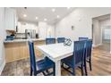 Well-lit dining area features a white table with six blue chairs near the kitchen at 306 Southgate Ct., Pawleys Island, SC 29585