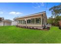 This home has a large lush green backyard with a glass enclosed outdoor living space at 409 14Th Ave. S, North Myrtle Beach, SC 29582