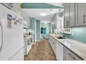Galley kitchen with stainless steel appliances, tile backsplash, and white cabinets, offering a clean, modern design at 454 Sean River Rd., Conway, SC 29526