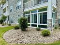Attractive exterior featuring a glass-enclosed porch and well-maintained landscaping at 4783 Wild Iris Dr. # 101, Myrtle Beach, SC 29577