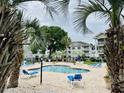 Relaxing pool area with palm trees and lounge chairs for residents at 4783 Wild Iris Dr. # 101, Myrtle Beach, SC 29577