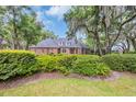 Beautiful brick home showcasing lush landscaping and moss-draped trees at 520 Chapman Loop, Pawleys Island, SC 29585