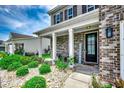 Inviting front porch adorned with lush landscaping and a welcoming 'Welcome' sign at 5406 Longhorn Dr., Myrtle Beach, SC 29588