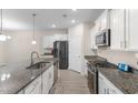 Modern kitchen with granite countertops, stainless steel appliances, and white cabinetry at 736 Flowering Branch Ave., Little River, SC 29566