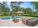Resort-style pool area with ample seating, lush landscaping, and golf course views at 78 Oakmont Dr., Pawleys Island, SC 29585