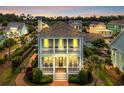 Charming two-story home featuring double porches and manicured landscaping at sunset at 8185 Sandlapper Way, Myrtle Beach, SC 29572