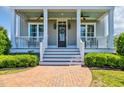 Charming covered porch with rocking chairs and a decorative wreath on the front door at 8185 Sandlapper Way, Myrtle Beach, SC 29572