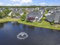 Beautiful backyard with view of a tranquil lake with fountain surrounded by neighborhood homes and verdant trees at 8204 Caddis Ct., Myrtle Beach, SC 29579