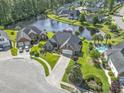 Stunning aerial view of a brick home with pool overlooking a serene lake in a lush community at 8204 Caddis Ct., Myrtle Beach, SC 29579