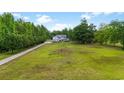 Expansive front yard view leading up to a charming two-story home surrounded by lush trees at 856 W Highway 9, Longs, SC 29568