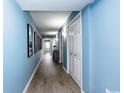 Hallway with wood floors, blue walls and white trim leads to a bedroom or bathroom at 8560 Queensway Blvd. # 1109, Myrtle Beach, SC 29572