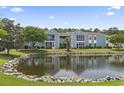 Stunning view of a condo complex near a tranquil pond and verdant green space at 8862 Duckview Dr. # E, Surfside Beach, SC 29575