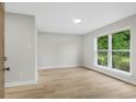 Bright living space showcasing hardwood floors and a large window with views of the green outdoors at 1015 Elm St. # 4, Conway, SC 29526