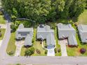 Aerial view of three well-manicured homes in a tree-lined neighborhood with manicured lawns at 1105 Lampwick Ln., Murrells Inlet, SC 29576