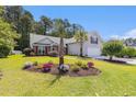 Well-maintained home featuring lush landscaping, palm trees, and a charming walkway at 1105 Lampwick Ln., Murrells Inlet, SC 29576