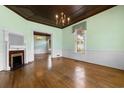 Well-lit living room with a fireplace, wood floors, large window and view to other room at 118 Ford Ave, Mullins, SC 29574