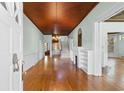 Open living room with hardwood floors, wainscoting, wood ceiling, chandelier and fireplace at 118 Ford Ave, Mullins, SC 29574
