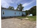 Light blue house with white trim, brick foundation, landscaped garden, and rear entrance at 1659 Sw Beach Dr., Sunset Beach, NC 28468