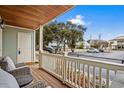 Inviting covered porch featuring comfortable seating, a wood ceiling, and views of the parking area at 2102 S Ocean Blvd. # D, North Myrtle Beach, SC 29582