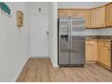 Bright kitchen with stainless steel refrigerator, wood cabinets, granite countertops and durable wood-look flooring at 2103 Sweetwater Blvd. # 2103, Murrells Inlet, SC 29576