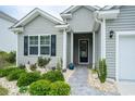 Inviting front entrance with a walkway, landscaping, and stylish front door at 251 Juniata Loop, Little River, SC 29566