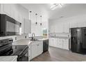 Modern kitchen with white cabinets, stainless steel appliances, and stylish lighting fixtures at 2951 Mary Hines Ln., Georgetown, SC 29440