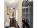 Inviting entryway with dark wood floors, a comfortable bench, and a staircase leading to the upper level at 3334 Volterra Way # 3334, Myrtle Beach, SC 29579