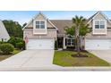 Charming brick townhome with a two-car garage, mature palm tree, and well-maintained lawn and landscaping at 3334 Volterra Way # 3334, Myrtle Beach, SC 29579