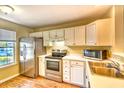 Kitchen featuring stainless steel appliances, white cabinetry, and laminate flooring at 3565 Crepe Myrtle Ct. # 3565, Myrtle Beach, SC 29577