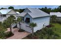 Rear view of a two-story beach home with metal roof, garage, and brick driveway at 374 Graytwig Circle, Murrells Inlet, SC 29576