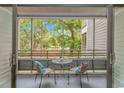 Screened porch features a cozy seating area with a small table and scenic outdoor views at 415 Ocean Creek Dr. # 2245, Myrtle Beach, SC 29572