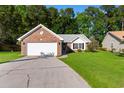 Inviting brick and vinyl home with a well-maintained lawn and long driveway leading to a two-car garage at 4171 Wrens Crossing, Little River, SC 29566