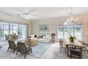 Bright living room featuring a modern sofa, wood coffee table, chandelier, and a sunroom at 4683 Wild Iris Dr. # 104, Myrtle Beach, SC 29577