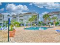 Community pool area with blue lounge chairs, palm trees, and well-maintained landscaping at 4683 Wild Iris Dr. # 104, Myrtle Beach, SC 29577
