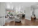 Open-concept living room with modern furniture and hardwood floors that seamlessly connects to the kitchen and dining area at 4832 Williams Island Dr., Little River, SC 29566