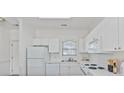 All-white kitchen features modern appliances and plentiful counter space, perfect for any home chef at 4879 Dahlia Ct. # 302, Myrtle Beach, SC 29577