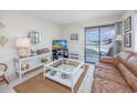 Relaxing living area with a TV, decorative items, and access to a balcony with water views at 5001 N Ocean Blvd. # 1F, North Myrtle Beach, SC 29582