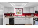 Bright kitchen with white cabinets, black appliances, and red accent wall at 507-C 2Nd Ave. N, North Myrtle Beach, SC 29582