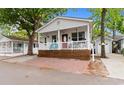 Charming cottage featuring a welcoming front porch and a brick paved parking area, perfect for guests at 6001 South Kings Hwy., Myrtle Beach, SC 29575