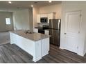 Modern kitchen featuring a granite island, stainless steel appliances, and sleek white cabinets at 642 Muster Field Ct., Conway, SC 29526