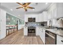 Modern kitchen with stainless steel appliances, white cabinetry, and mosaic tile backsplash at 1014 Thomas Ave., North Myrtle Beach, SC 29582